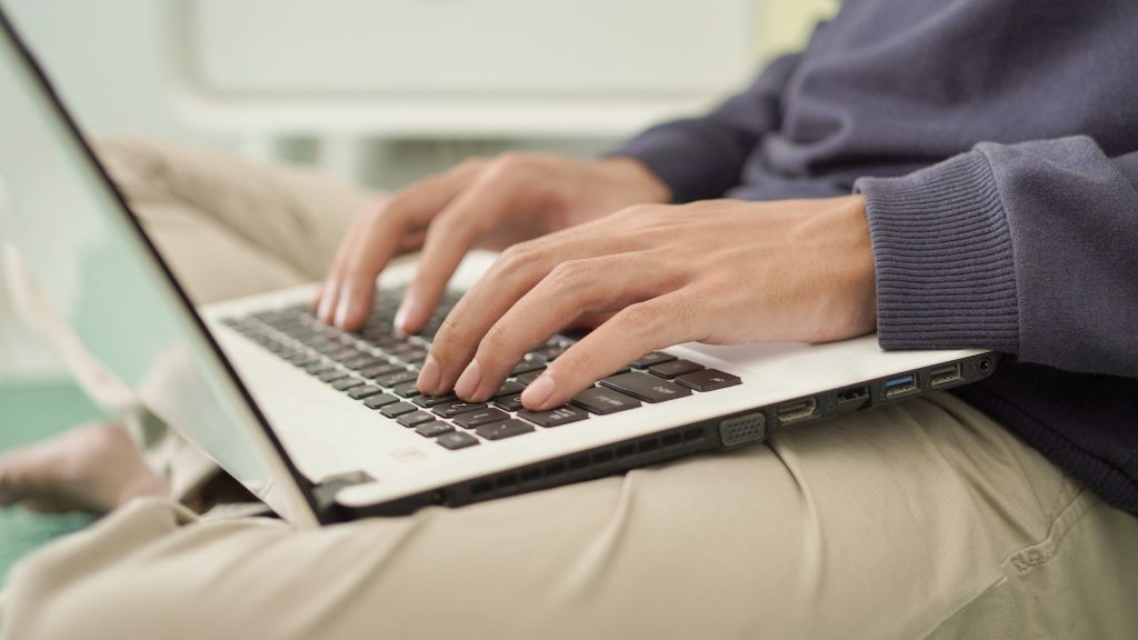 man typing laptop at home